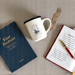 Stylish bookish merchandise like a literary mug, a unique bookmark, and a reading journal, artistically arranged