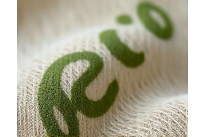 Close-up of sustainable fabric texture, with a subtle tag indicating organic or recycled materials.